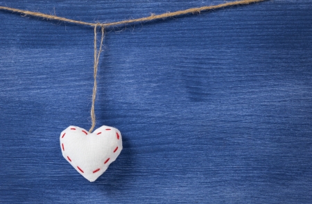 single textile hearts over wooden wall, can be used as a backgroundの写真素材