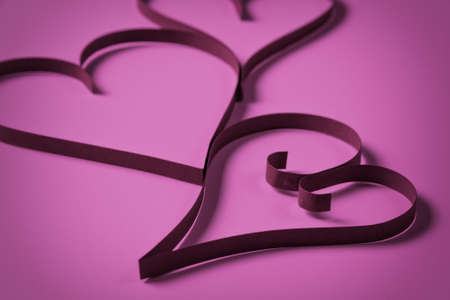 three paper hearts on purple paper, valentines day backgroundの写真素材