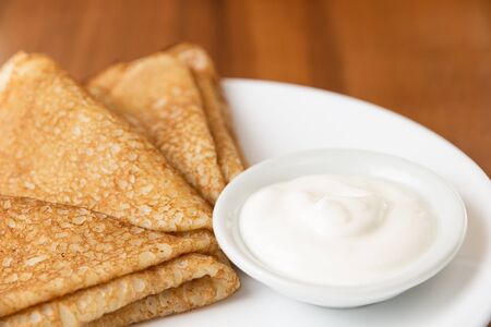 russian crepes with sour cream, on plateの写真素材