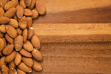 roasted almonds on wooden table, food backgroundの写真素材