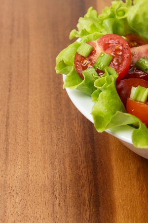fresh light salad with cherry tomatoes and chives, on tableの写真素材