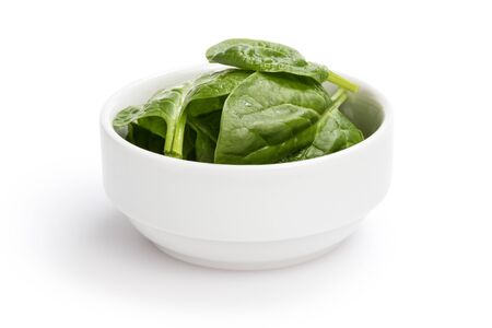 fresh spinach leaves in bowl, isolated on whiteの写真素材
