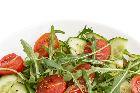 salad from ruccola, cherry tomatoes and cucumber, on white backgroundの写真素材