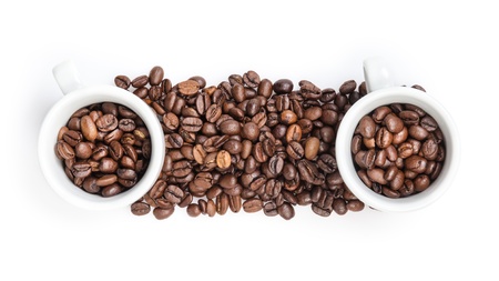 heap of coffee beans with two cups, isolated on whiteの写真素材