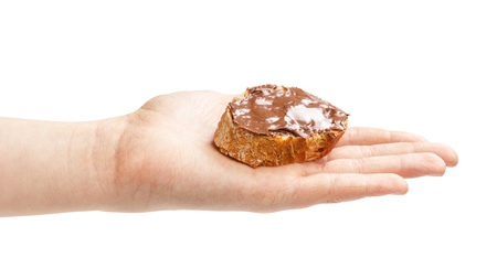 baguette slice spread with nut-choco paste in female hand, isolated on whiteの写真素材