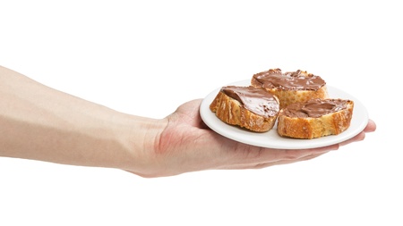 baguette slices spread with nut-choco paste in man hand, isolated on whiteの写真素材