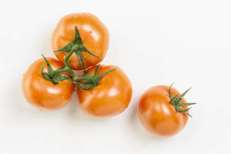 yellow tomatoes with branch, on white wood tableの写真素材