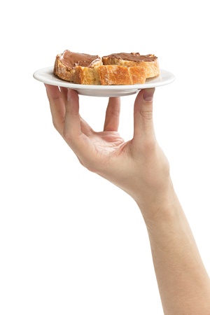 baguette slices spread with nut-choco paste in man hand, isolated on whiteの写真素材