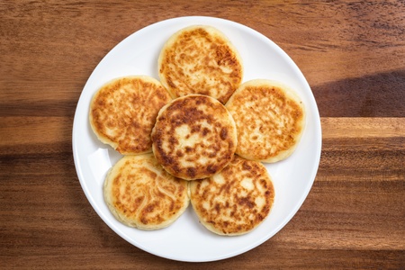 delicious traditional cheese pancakes in plate on wooden table