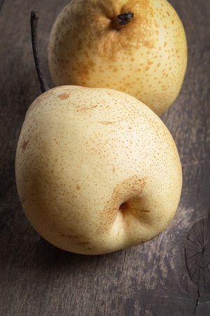 two asian ripe yellow pears on old wooden table, selective focusの写真素材