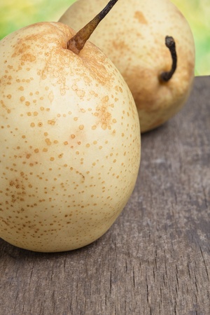 two asian ripe yellow pears on old wooden table, selective focusの写真素材