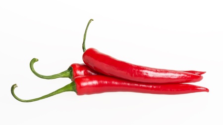 three red chili peppers, isolated on whiteの写真素材