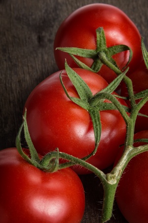 tomatoes on a branch on wooden table, selective focusの写真素材