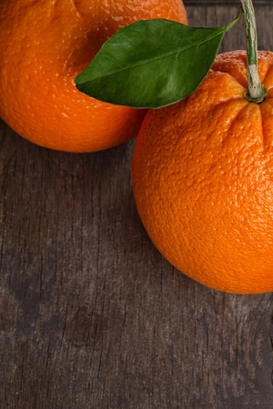 ripe round orange with stem and leaf on wooden table, selective focusの写真素材