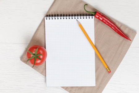 recipe notepad on wooden table with pepper and tomato with pencilの写真素材