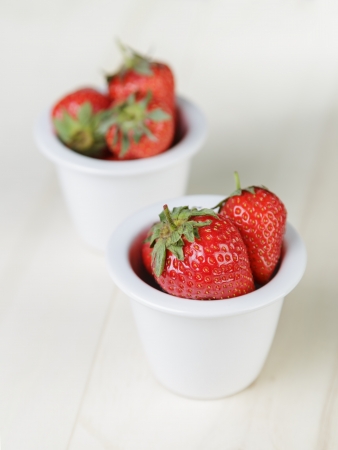 ripe strawberries in bowl, on wood tableの写真素材