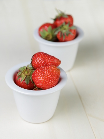 ripe strawberries in bowl, on wood tableの写真素材