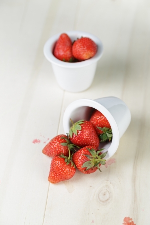 ripe strawberries in bowl, on wood tableの写真素材