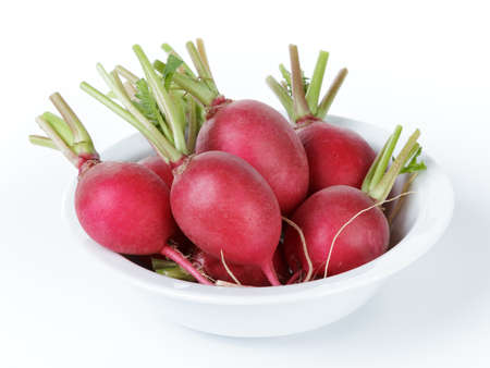 heap of ripe radishes in plate, isolated on white backgroundの写真素材