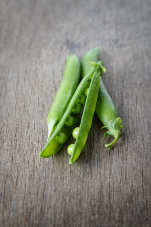 heap of fresh pea pods, on wood tableの写真素材