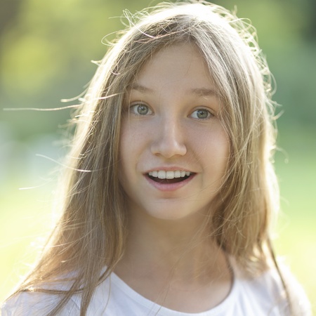 surprised teen girl outdoors, vertical portrait with backlightの写真素材