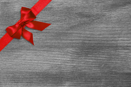 red ribbon bow on wooden surface, invitation templateの写真素材