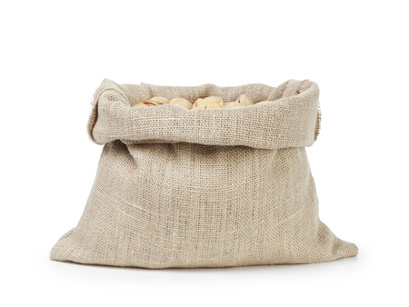 roasted salty pistachios nuts in sack bag, isolated on white backgroundの写真素材