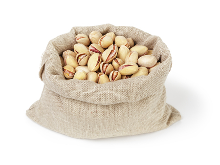 roasted salty pistachios nuts in sack bag, isolated on white backgroundの写真素材