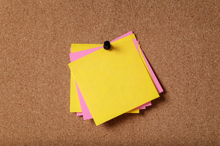 bunch of empty sticky notes on cork board