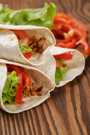 burrito with meat and ingredients on old wooden table rustic styleの写真素材