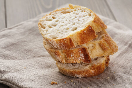 slices of fresh french baguette on table, rustic style