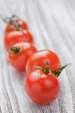 cherry tomatoes on white painted wood table, selective focusの写真素材