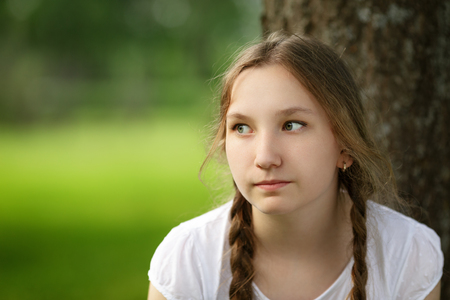 girl sit near tree in park, resting in parkの写真素材