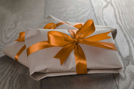 vintage style gifts tied with ribbon and bow, on old oak tableの写真素材