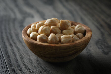 peeled hazelnuts in bowl on old oak tableの写真素材