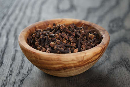 cloves in olive bowl on oak table, christmas spiceの写真素材