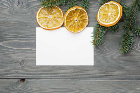 spruce twig with dried orange slices and greeting card, christmas backgroundの写真素材