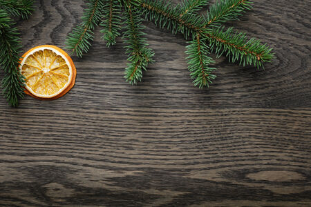 spruce twig with dried orange slices on oak table, christmas backgroundの写真素材