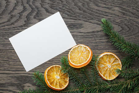 spruce twig with dried orange slices on oak table, christmas backgroundの写真素材