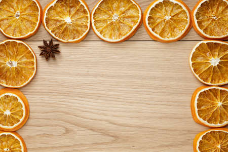dried orange slices on natural oak table, holiday backdropの写真素材