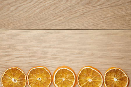 dried orange slices on natural oak table, holiday backdropの写真素材