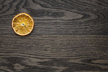dried orange slice on dark oak table, holiday backdropの写真素材