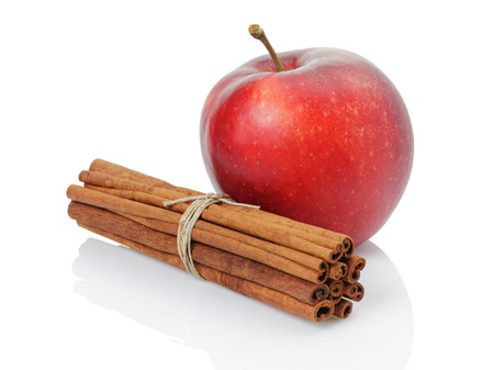 red ripe apple and cinnamon sticks, isolated on whiteの写真素材