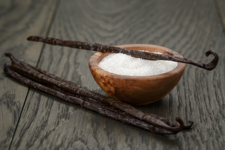 bourbon vanilla pods with white sugar on wood table, simpe dark photoの写真素材