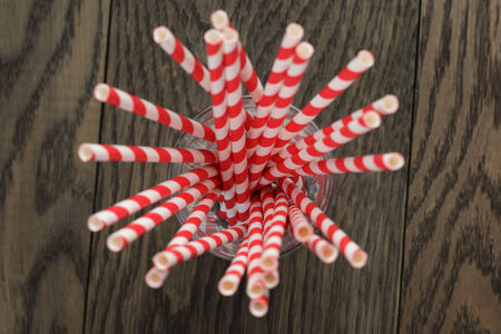 vintage paper straws in glass on wood table, rustic styleの写真素材