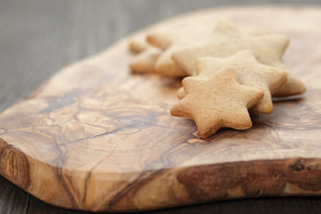 homemade star shape ginger cookies on olive board, rustic photoの写真素材