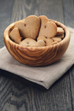 heart cookies for valentines day in olive bowl on wood table, valentines day themeの写真素材