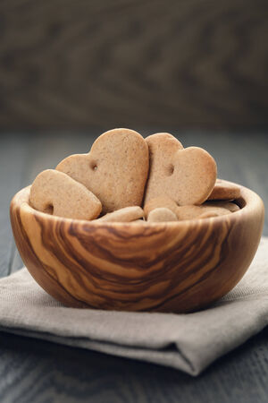heart cookies for valentines day in olive bowl on wood table, valentines day themeの写真素材
