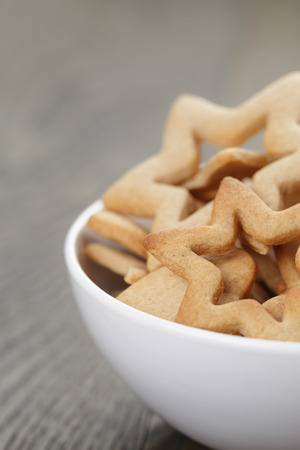 classic star cookies in white bowl, on wood tableの写真素材