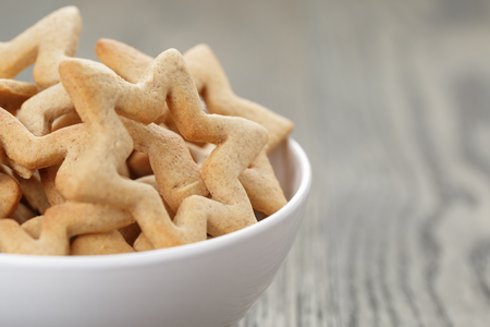 classic star cookies in white bowl, on wood tableの写真素材